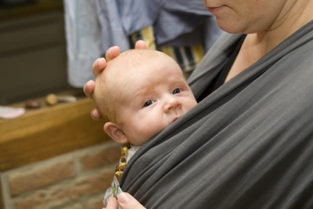 Kleines Baby, getragen von seiner Mutter in einem praktischen Wickeltuch